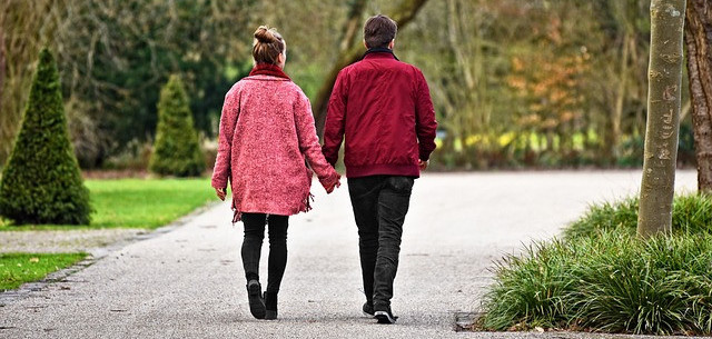 A couple walking together hand in hand in the park